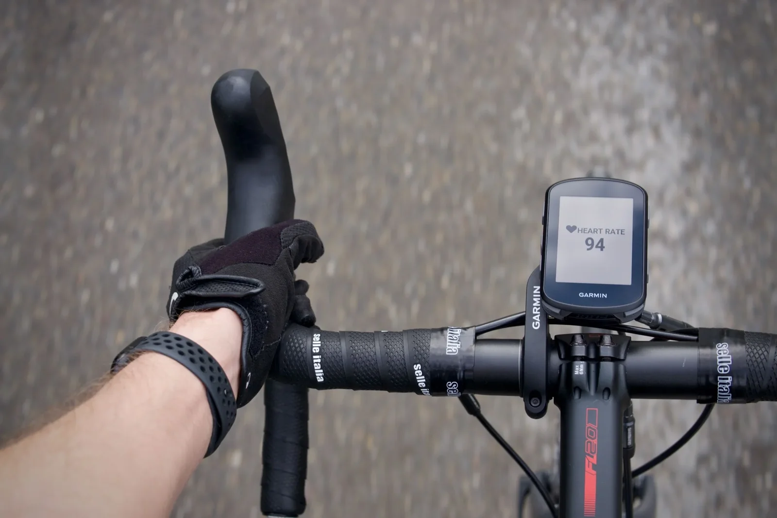Garmin Edge mounted on handlebars showing live heart rate from Apple Watch via HRM app